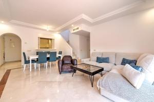 Luxury penthouse in Jardines de Don Carlos في مربلة: غرفة معيشة مع أريكة وطاولة