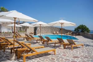 a group of chairs and umbrellas next to a pool at Pagoda Lifestyle Hotel in Ischia