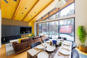 白馬村にあるCredence Chalets by HHGのテーブルと椅子とソファのあるダイニングルーム