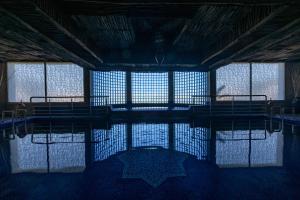 a swimming pool in a building with windows at Chateau Eden El Rouh & Spa in Oualidia