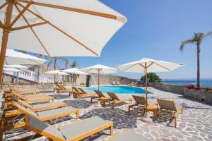 a group of chairs and umbrellas next to a pool at Pagoda Lifestyle Hotel in Ischia