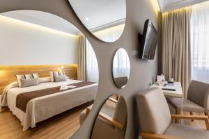 um quarto de hotel com uma cama e um espelho em Monte Carmelo em Sevilha