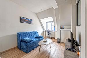 a living room with a blue couch and a table at Studio Christiane - en plein coeur de Roscoff in Roscoff