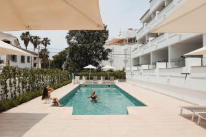 un grupo de personas sentadas en una piscina en Hoposa Pollensamar Apartamentos, en Puerto Pollensa