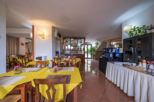 a restaurant with yellow tables and chairs in a room at Casa Betania - Parcheggio Gratuito in Pisa