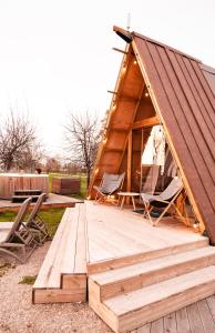 een houten terras met 2 stoelen en een tent bij Nabi Resort Glamping & SPA in Castel Volturno