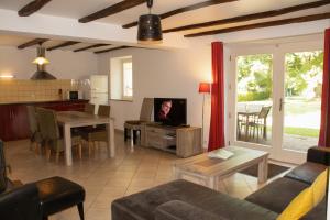 a living room with a couch and a table with a tv at Domaine Les Bachats in Rhodes