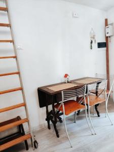 a dining room table with two chairs and a ladder at La Casa di Antonietta in Fosdinovo