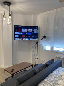 sala de estar con sofá y TV en la pared en Bravo Murillo Apartments, en Madrid
