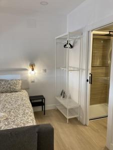 1 dormitorio con 1 cama y ducha a ras de suelo en Bravo Murillo Apartments, en Madrid
