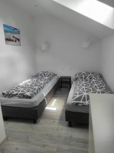 dwa łóżka siedzące obok siebie w pokoju w obiekcie Domki na Polnej w Grzybowie