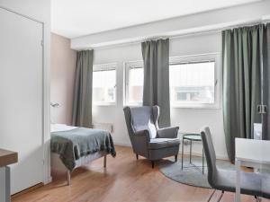 una camera con letto, sedia e tavolo di Part-Time Home Rotebro Station a Stoccolma