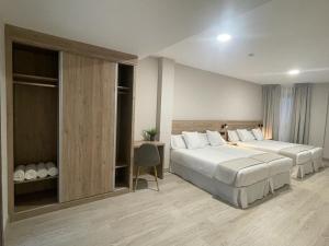 a hotel room with two beds and a desk at URBAN Pensión in Melide