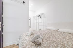 a white bedroom with a bed with towels on it at Arturo Soria Apartments3 in Madrid