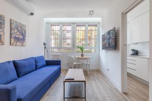 sala de estar con sofá azul y mesa en Arturo Soria Apartments3, en Madrid