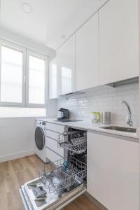 cocina blanca con lavavajillas y fregadero en Arturo Soria Apartments3, en Madrid