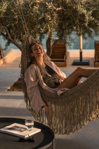 a woman is sitting in a hammock at Cook's Club Kolymbia Rhodes -Adults only in Kolimbia