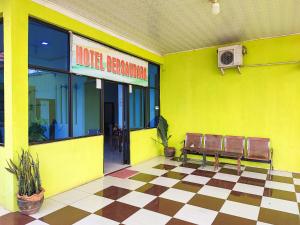 a yellow building with two benches in front of it at Reddoorz @ Hotel Bersaudara Bungo in Muarabungo