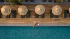 a person jumping into a swimming pool with umbrellas at Cook's Club Kolymbia Rhodes -Adults only in Kolymbia