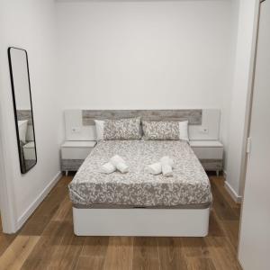 1 dormitorio blanco con 1 cama con 2 almohadas en Garcia Noblejas Apartments, en Madrid