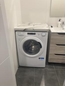 een wasmachine in een badkamer met een wastafel bij Ensanche1 Apartments in Madrid