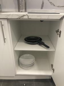 un armario blanco con una sartén y platos en él en Ensanche1 Apartments, en Madrid