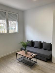 a living room with a couch and a table at San Sebastián Apartments in San Sebastián de los Reyes