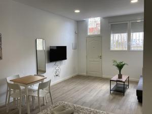 a living room with a table and a dining room at San Sebastián Apartments in San Sebastián de los Reyes