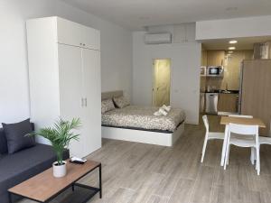 a small living room with a bed and a table at San Sebastián Apartments in San Sebastián de los Reyes