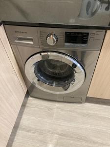 a washing machine with its door open in a kitchen at San Sebastián Apartments in San Sebastián de los Reyes