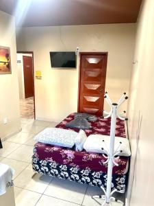 1 dormitorio con 1 cama y TV en la pared en Hotel Fortaleza II Manaus, en Manaus