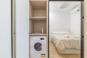 Zimmer mit einer Waschmaschine und einem Bett in der Unterkunft Arturo Soria Apartments2 in Madrid
