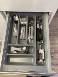 a drawer filled with silver utensils in a cabinet at Plaza Castilla Apartments in Madrid