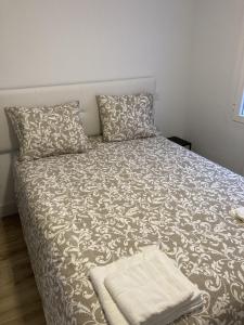 Plaza Castilla Apartments في مدريد: سرير مع بطانية ومخدات في غرفة النوم