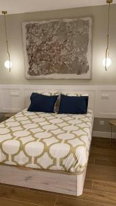 una camera da letto con un grande letto con cuscini blu di Nuevo piso Retiro a Madrid