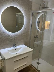 a bathroom with a sink and a shower with a mirror at Nuevo piso Retiro in Madrid