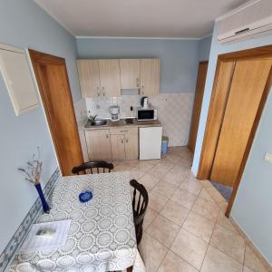 a small kitchen with a table and a table and chairs at Villa Margarita in Selce
