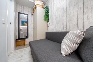 a gray couch in a living room with a pillow at Hauzify I Apartament Turismar in Platja  d'Aro
