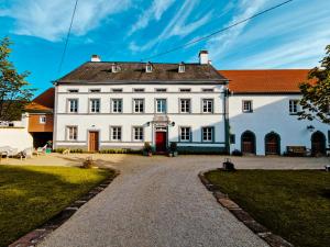 a large white building with a red roof at Gutshaus De La Fontaine in Feilsdorf
