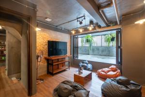 a living room with a large window and a television at House of Machine Boutique Hotel in Bangkok