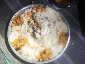 a bowl of rice with meat and vegetables on a table at The White Bedouin in Wadi Rum