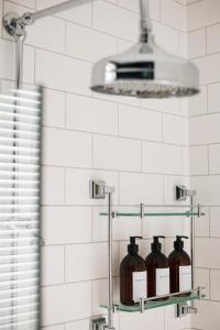 a bathroom with three glass bottles on a shelf at Eden Grove - Islington - Studio Apartment in London