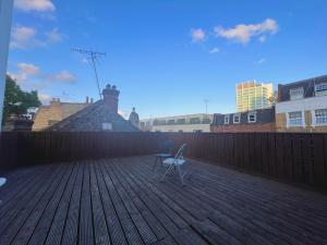 a chair sitting on top of a wooden deck at Lovely 2 Bedroom Apartment with Balcony - Euston in London
