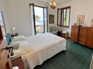 ein Schlafzimmer mit einem großen weißen Bett und einem Fenster in der Unterkunft Villa con vista Sestri Levante in Sestri Levante