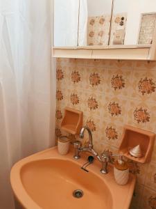 a bathroom with a sink and a mirror at Almare House near Airport in Áyios Spirídhon