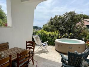 einen Whirlpool auf einer Terrasse mit Stühlen und einem Tisch in der Unterkunft Villa con vista Sestri Levante in Sestri Levante