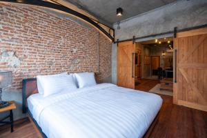a bed in a room with a brick wall at House of Machine Boutique Hotel in Bangkok