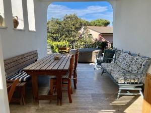 eine Veranda mit einem Holztisch und Stühlen auf einer Terrasse in der Unterkunft Villa con vista Sestri Levante in Sestri Levante