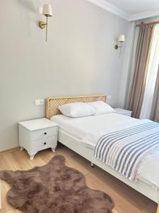 ein weißes Schlafzimmer mit einem Bett und einem Teppich in der Unterkunft Taşköprü Suit Bungalov in Hemşin