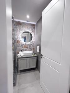 ein Badezimmer mit Badewanne, Waschbecken und Spiegel in der Unterkunft Zeus & Emmanuil Luxury Houses in Mirina